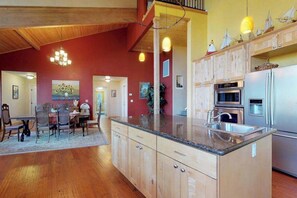 A spacious kitchen with wooden cabinets, a granite countertop, and stainless steel appliances.