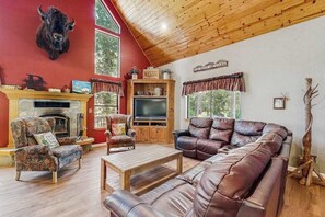 A cozy living room with a fireplace, leather sofa, and a mounted bull head decoration. - The Rockin' Buffalo - Granite Ridge (Shaver Lake)