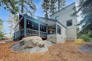 A modern two-story building with a large rock in the foreground, surrounded by trees. - Whispering Pines - Sierra Cedars (Shaver Lake)