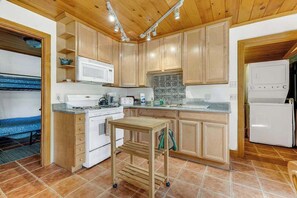 A kitchen with wooden cabinets, a white stove, a microwave, and a refrigerator. - Yosemite Mountain Cottage - Groveland (Groveland)