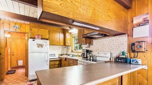 A kitchen with wooden cabinets, a refrigerator, a microwave, and a stove. - The Jug Handle Hideaway - Snowshoe Springs (Arnold)