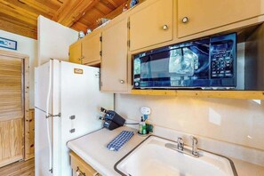 Une cuisine compacte équipée d’un réfrigérateur, d’un four à micro-ondes et d’un évier.