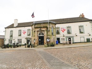 A traditional pub with a stone facade, a central entrance, and a flagpole. - 10 Poppy Lodge (Richmond)