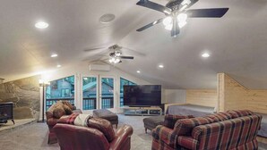 A cozy living room with a fireplace, a large flat-screen TV, and a ceiling fan. - Tranquil Pines Estate - Ridgetop (Shaver Lake)