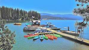 A lakeside dock with canoes, a small building, and a dockside rental area. - Tranquil Pines Estate - Ridgetop (Shaver Lake)