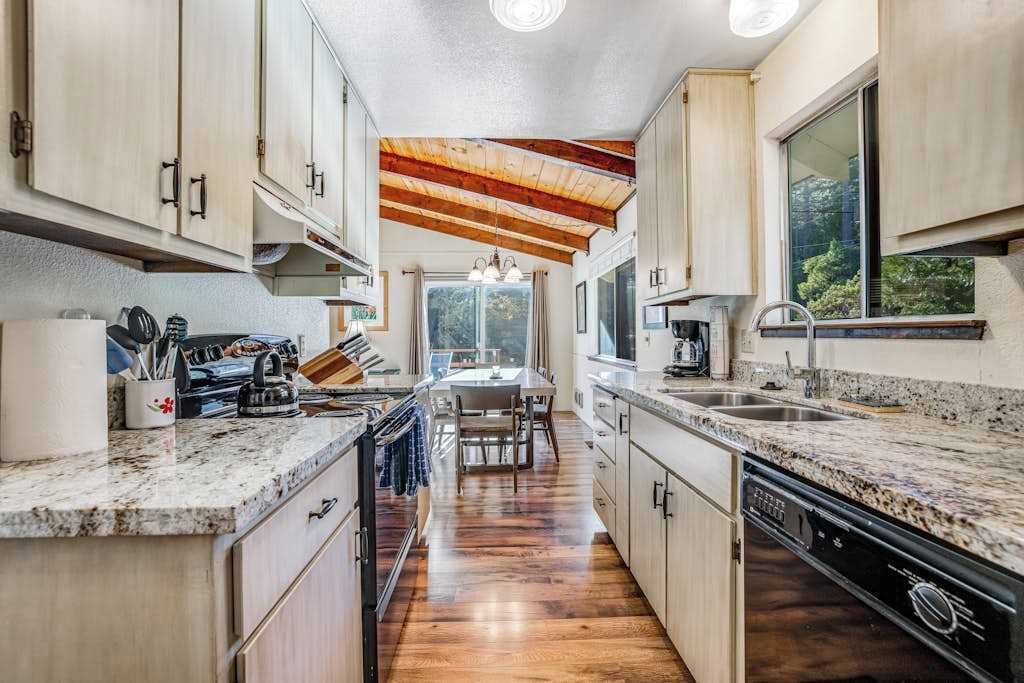 A kitchen with wooden cabinets, granite countertops, and a central island.