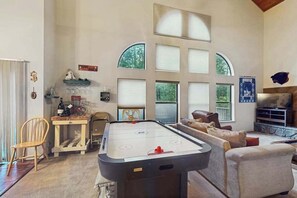 Ein Zimmer mit Pooltisch, Sitzecke und großen Fenstern.