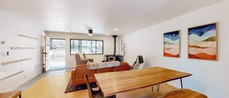 Un interior moderno con una mesa de comedor de madera, un sofá y una chimenea.