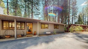 A single-story building with a covered porch, large windows, and a driveway. - Piney Point - Meadowmont (Arnold)