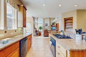 A spacious kitchen with granite countertops, wooden cabinets, and a central island. - Hemlock Hacienda - Pine Mountain Lake (Groveland)