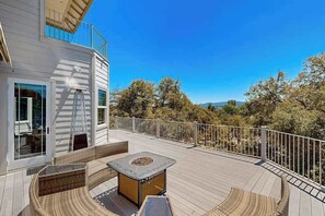 A deck with outdoor furniture, a fire pit, and a view of trees and hills. - Hemlock Hacienda - Pine Mountain Lake (Groveland)