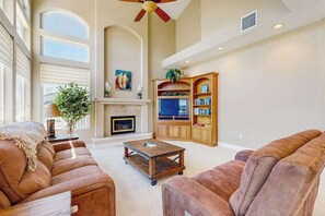 A spacious living room with a fireplace, a television, and a bookshelf. - Hemlock Hacienda - Pine Mountain Lake (Groveland)