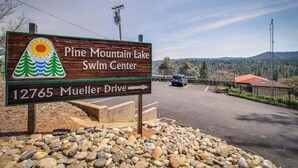 En skylt för Pine Mountain Lake Swim Center, med en pil som visar vägen till Mueller Drive.