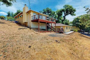 A two-story house with a wooden deck and a covered porch. - Walling Mountain Retreat - Pine Mountain Lake (Groveland)