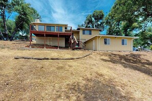 A two-story house with a covered porch and a small deck. - Walling Mountain Retreat - Pine Mountain Lake (Groveland)