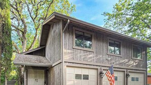 A two-story house with a garage, a front porch, and an American flag. - Pleasant Pines Retreat - Pine Mountain Lake (Groveland)