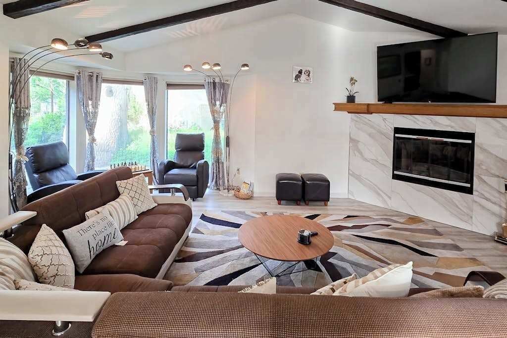 Ein modernes Wohnzimmer mit einem Ecksofa, einem Couchtisch und einem Kamin.