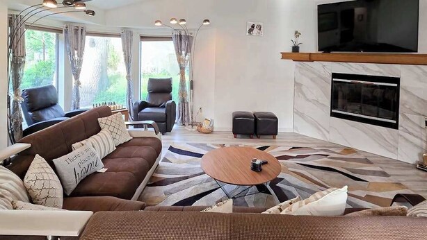 A modern living room with a sectional sofa, a coffee table, and a fireplace. - Pleasant Pines Retreat - Pine Mountain Lake (Groveland)