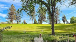 A golf course with a bench and trees in the foreground. - Pleasant Pines Retreat - Pine Mountain Lake (Groveland)