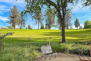 A golf course with a bench and trees in the foreground. - Pleasant Pines Retreat - Pine Mountain Lake (Groveland)