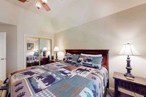 Ein Schlafzimmer mit einem großen Bett, einem Holzkopfstück, zwei Nachttischlampen und einem Spiegel an der Wand.