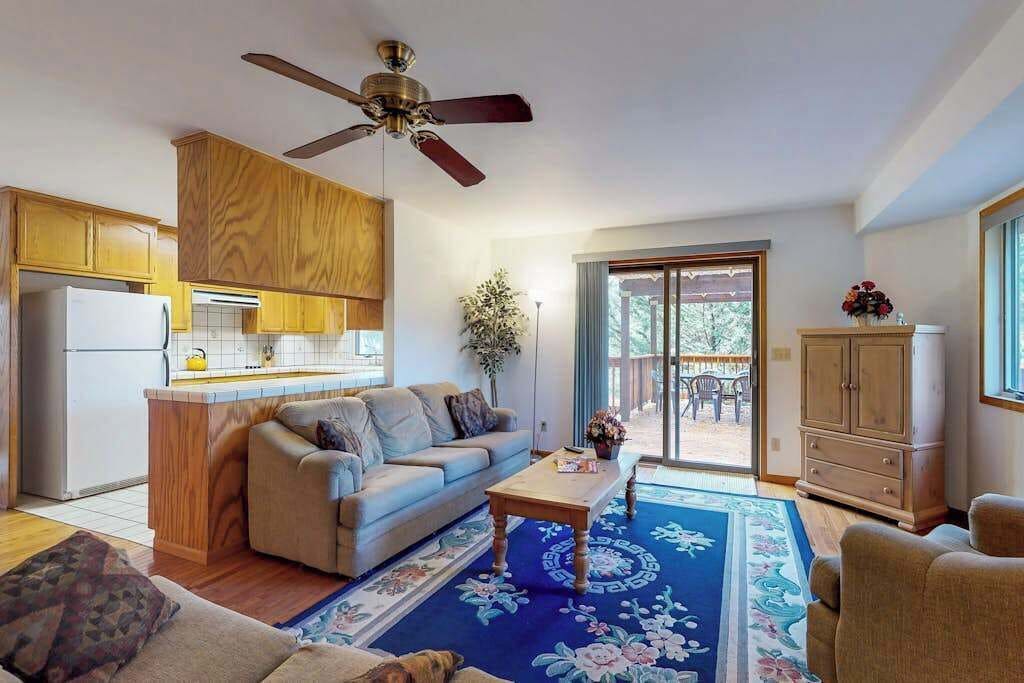 A living room with a sofa, coffee table, and a ceiling fan.