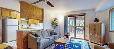 A living room with a sofa, coffee table, and a ceiling fan.