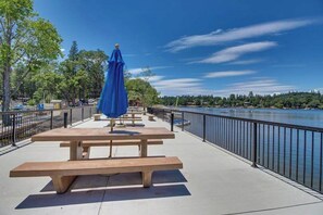 A riverside walkway with picnic tables and a blue umbrella. - Lake Lodge Retreat - Pine Mountain Lake (Groveland)