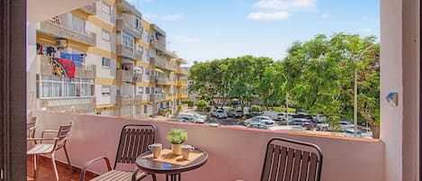 Ein Balkon mit Tisch, Stühlen und einem Blumentopf.