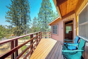 A wooden deck with a railing, a covered area with chairs, and a view of trees. - Rustic Retreat - Pine Mountain Lake (Groveland)