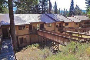 A row of cabins with a wooden deck connecting them, surrounded by trees. - Blue Jay Condominium - Huntington Lake (Lakeshore)