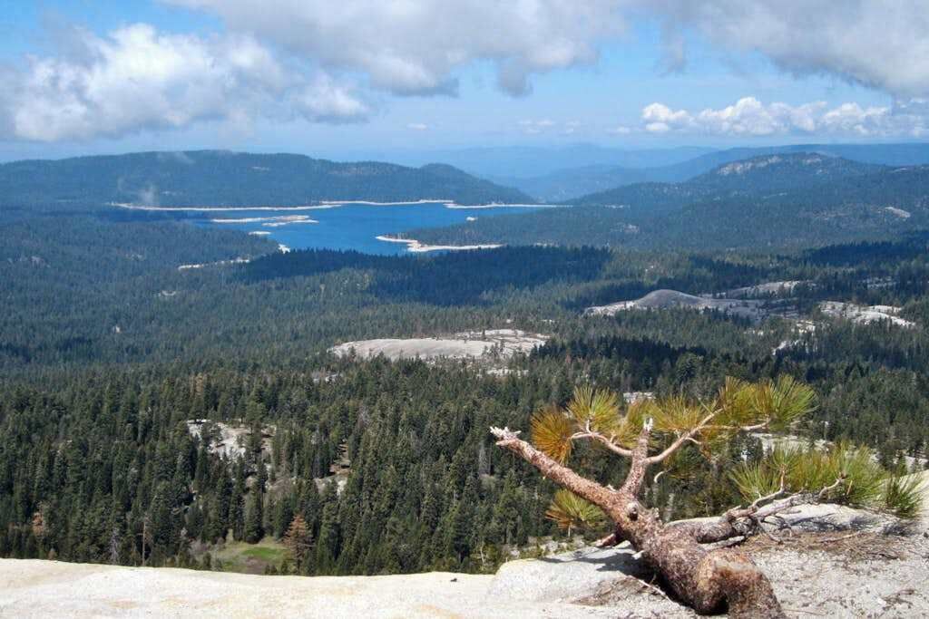 A mountainous landscape with a clear view of a lake and forested area.
