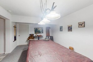 A room with a long table, a ceiling light fixture, and wall-mounted artwork. - Under The Stars - Shaver Lake (Shaver Lake)