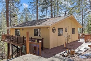 A wooden cabin with a deck, surrounded by trees. - Big Trees, Little Cabin - Meadowmont (Arnold)