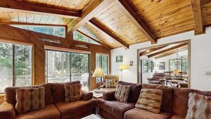 A cozy living room with a sectional sofa, large windows, and a wooden ceiling. - On The 9th - Blue Lake Springs (Arnold)