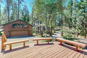 A wooden cabin with a deck, surrounded by trees. - Tranquil Pines Retreat - Ridgetop (Shaver Lake)