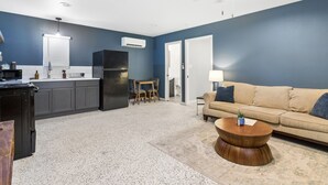 A compact living space with a kitchenette, a sofa, and a coffee table. - Main House + Modern Tiny Home - 4 BR / 3 BA (Nacogdoches)