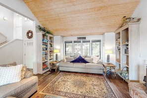 A living room with a sofa, a coffee table, a rug, and bookshelves. - Forest With A View - Musick Falls (Shaver Lake)