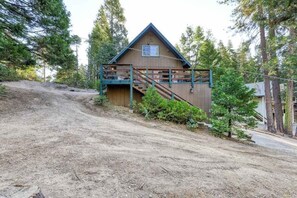 A wooden cabin with a balcony and stairs, surrounded by trees. - The Limit - West Village (Shaver Lake)