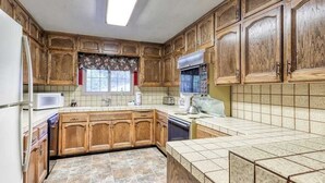 A kitchen with wooden cabinets, a microwave, a toaster, and a dishwasher. - The Limit - West Village (Shaver Lake)