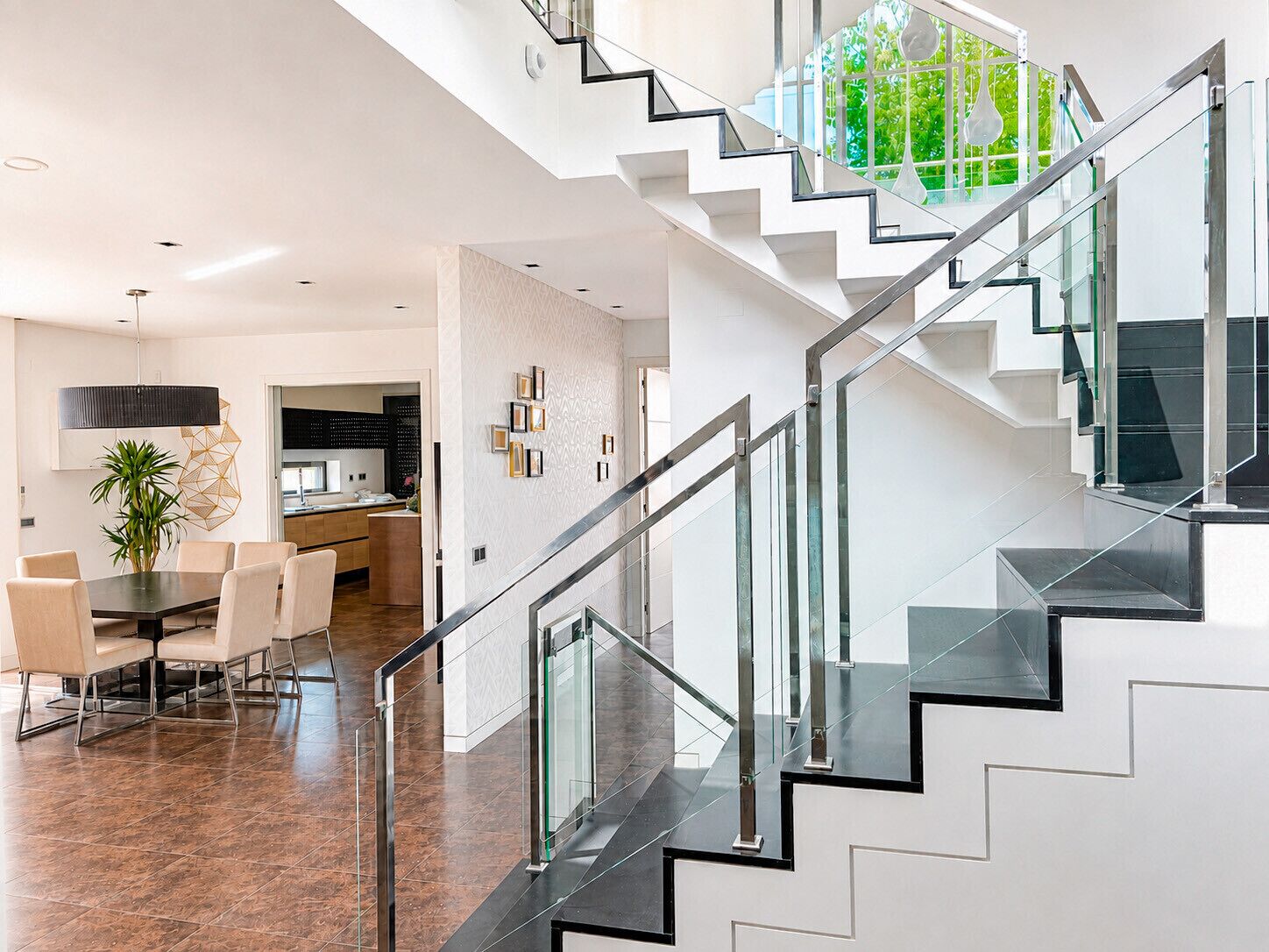 A modern interior with a staircase, dining area, and kitchen.