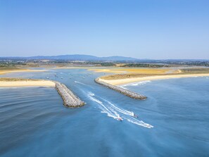 An aerial view of a coastal area with a clear sky, a sandy beach, and a waterway with boats. - Villa with jacuzzi & heatable pool in Olhão (Olhão)