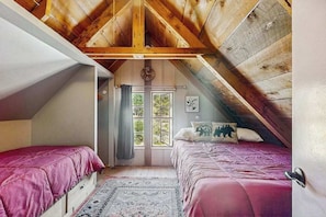 A bedroom with two beds, a window with curtains, and a wooden ceiling. - Forest Edge Hideaway - Musick Meadows (Shaver Lake)