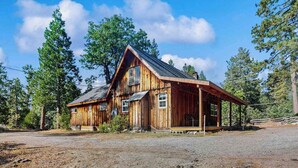 Eine Holzhütte mit Veranda, umgeben von Bäumen.