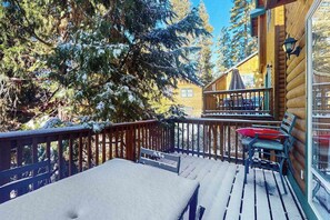 A wooden deck with a table and chairs, surrounded by snow-covered trees. - Baby Bear Bliss - Sierra Pines (Shaver Lake)