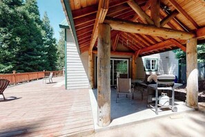 A covered outdoor area with a wooden deck, a grill, and a table with chairs. - Papa's Mountain Retreat - Shaver Lake (Shaver Lake)