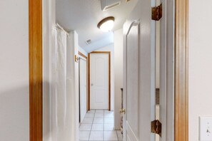 A hallway with white walls, a tiled floor, and a door at the end. - Papa's Mountain Retreat - Shaver Lake (Shaver Lake)