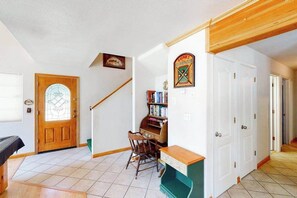 A room with a wooden door, a piano, a chair, and a bookshelf. - Papa's Mountain Retreat - Shaver Lake (Shaver Lake)