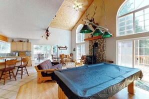 A spacious living area with a pool table, wooden furniture, and a stone fireplace. - Papa's Mountain Retreat - Shaver Lake (Shaver Lake)