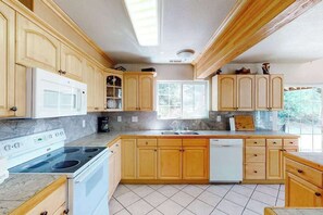 A kitchen with wooden cabinets, a white stove, and a dishwasher. - Papa's Mountain Retreat - Shaver Lake (Shaver Lake)